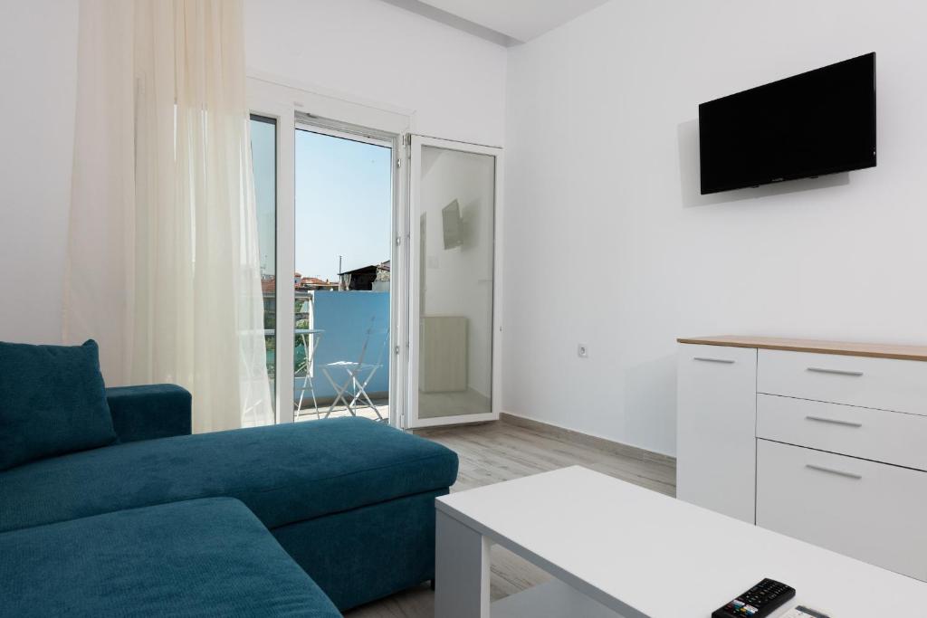 萨索斯Diamanti Apartments Downtown Limenas Thasos的客厅配有蓝色的沙发和电视