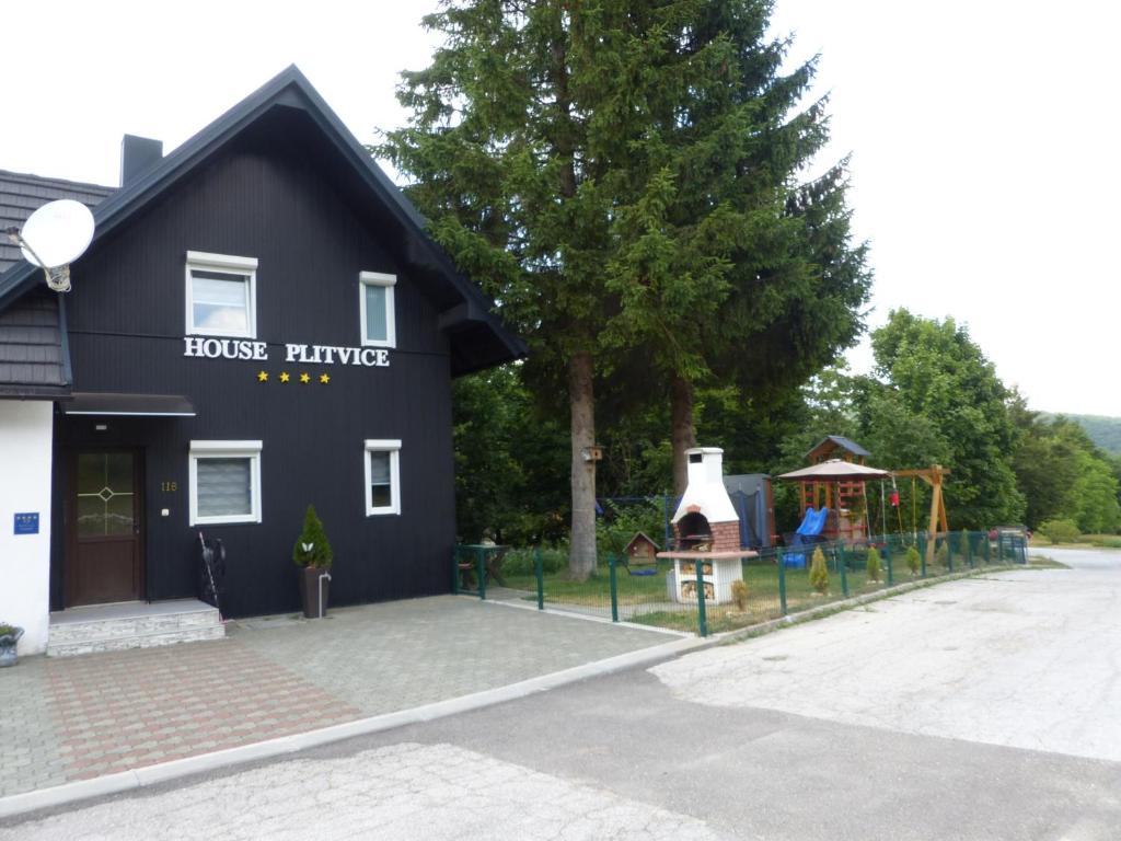 普利特维采湖普里特维采度假屋的一座黑色建筑,前面有一个游乐场