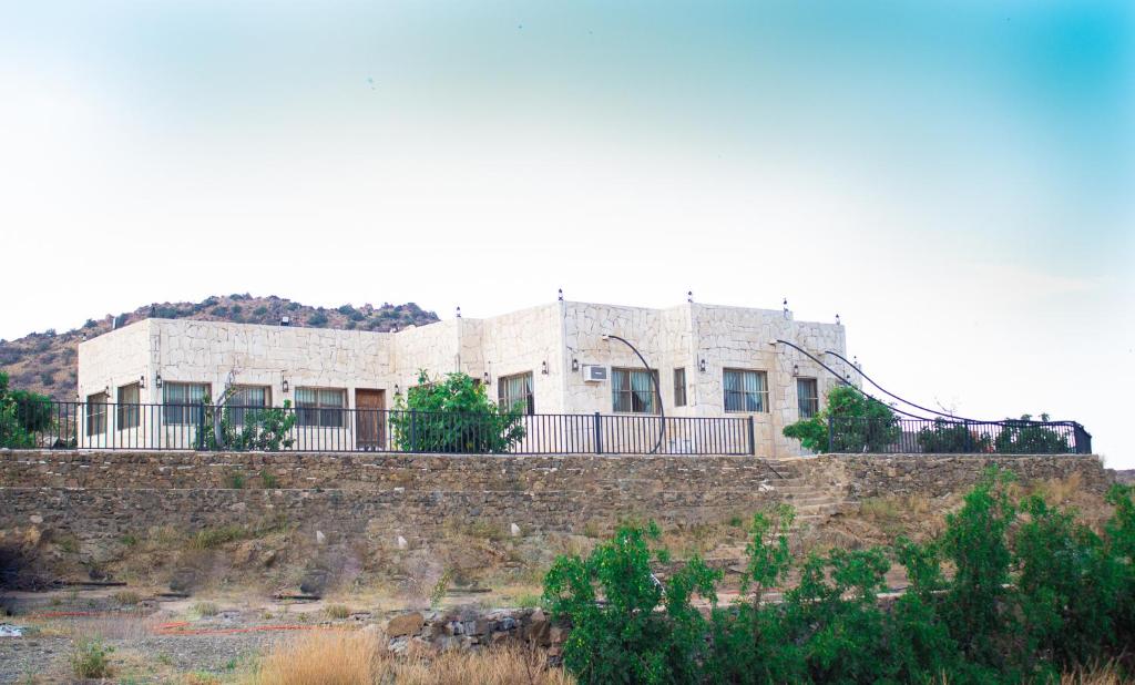 阿尔莎法فيلا الشفا الجبلية Al Shafa Villa的石墙顶部的建筑