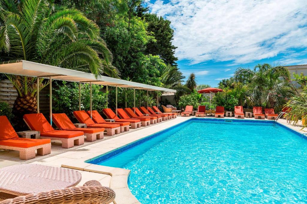 圣马克西姆Best Western Premier Montfleuri的一个带橙色躺椅的游泳池和一个游泳池