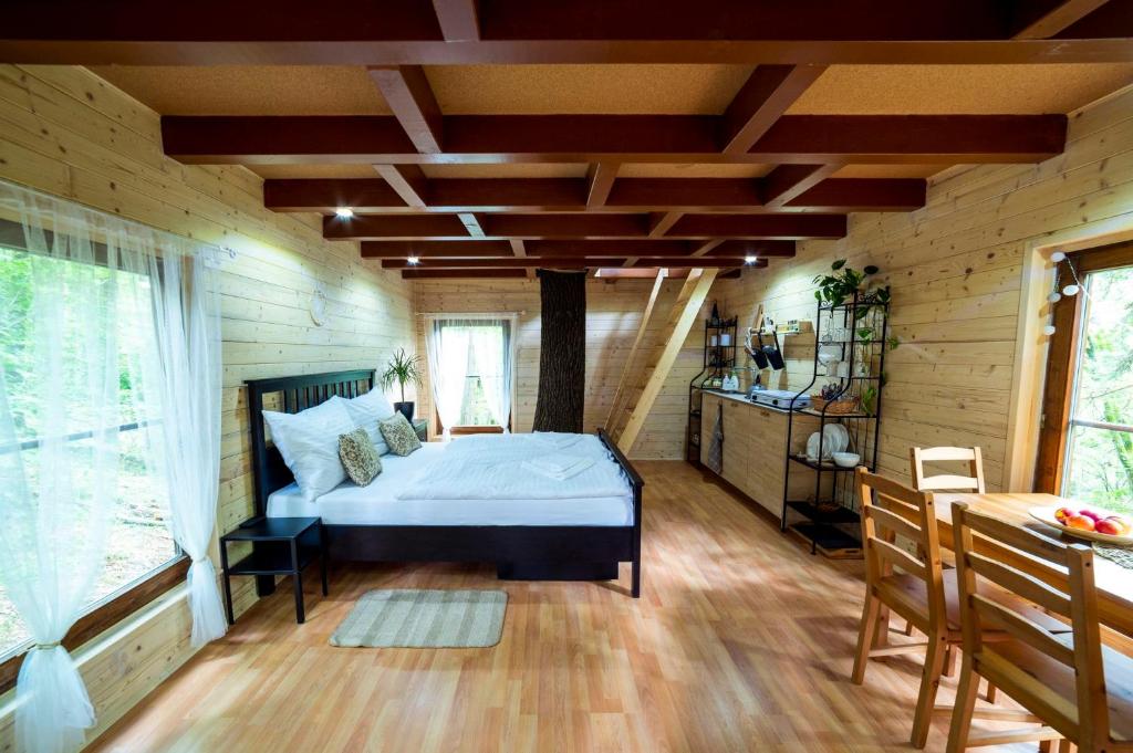 Zlatá KorunaTreehouse Zlatá Koruna的木制客房内的一间卧室,配有一张床