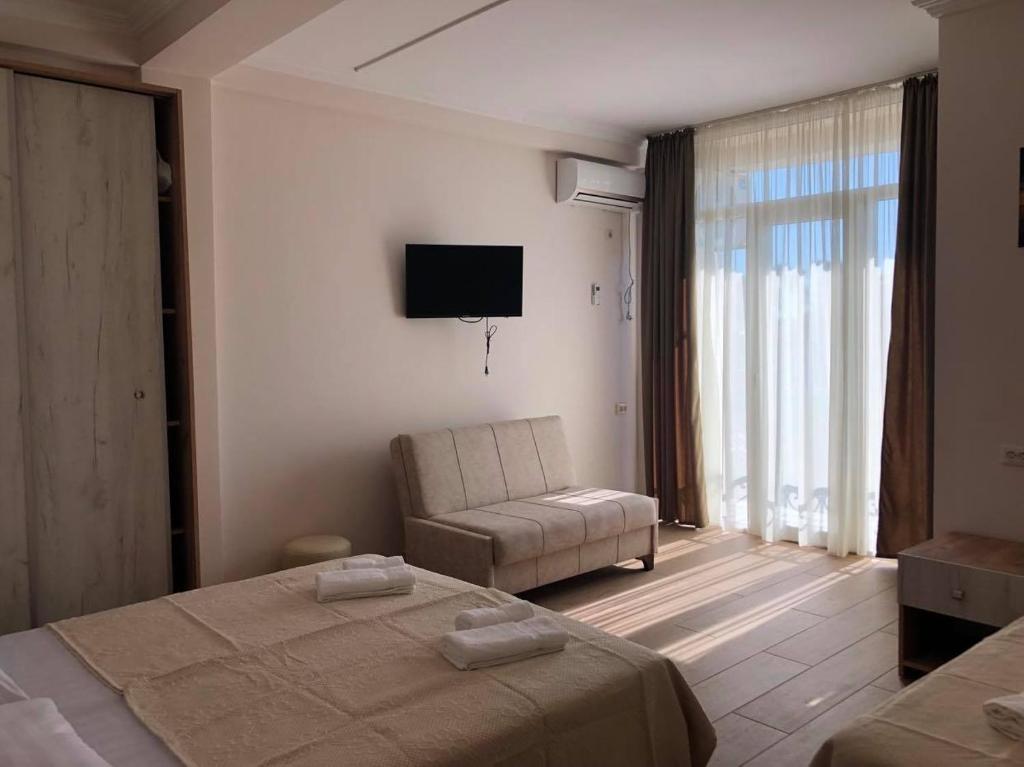 乌雷基Chaki Hotel的一间卧室配有一张床、一把椅子和电视