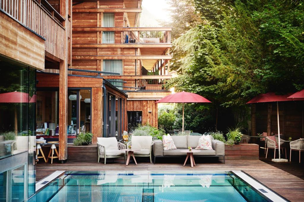 齐勒河谷采尔Small Luxury Hotel of the World - DasPosthotel的大楼前带游泳池的天井
