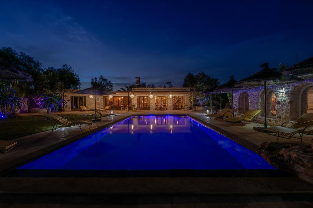 索维拉Absolu Beldi Essaouira的夜间在房子前面的游泳池