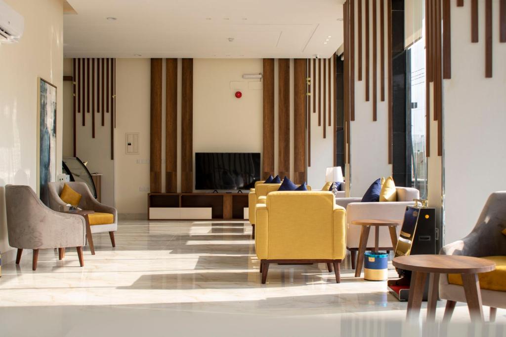 艾卜哈The Palace Hotel Suites - Al Badea的大堂设有黄色的椅子和桌子
