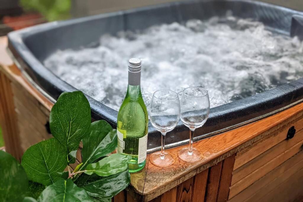 奥尔伯里Lux Central 3BR - outdoor spa的热水浴池内的一瓶香槟和两杯葡萄酒