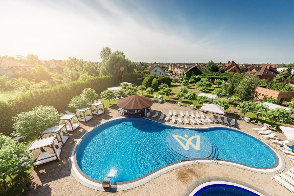VishenkiWISH Aqua&SPA Resort的享有带躺椅的大型游泳池和度假村的顶部景色