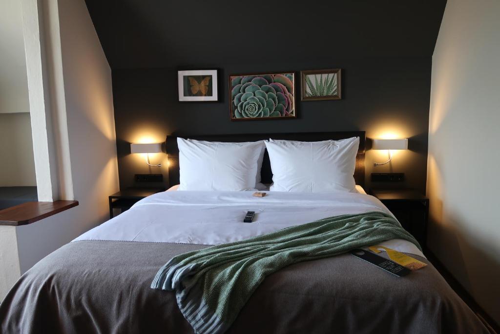 奥斯赛拜-屈隆斯博恩Lodge Boutique Hotel Kühlungsborn的一间卧室配有一张带两盏灯的大型白色床。