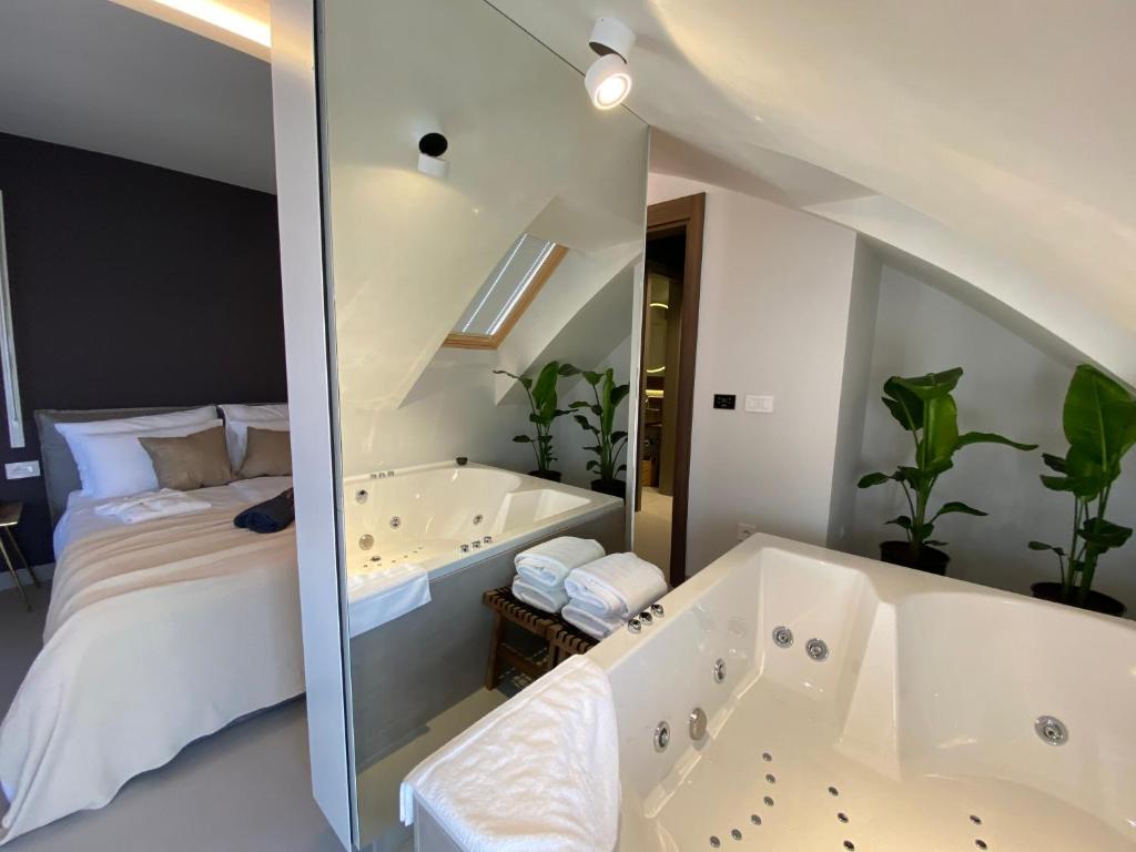 诺维萨德Korpa Deli Rooms SPA的卧室旁的浴室设有床和浴缸
