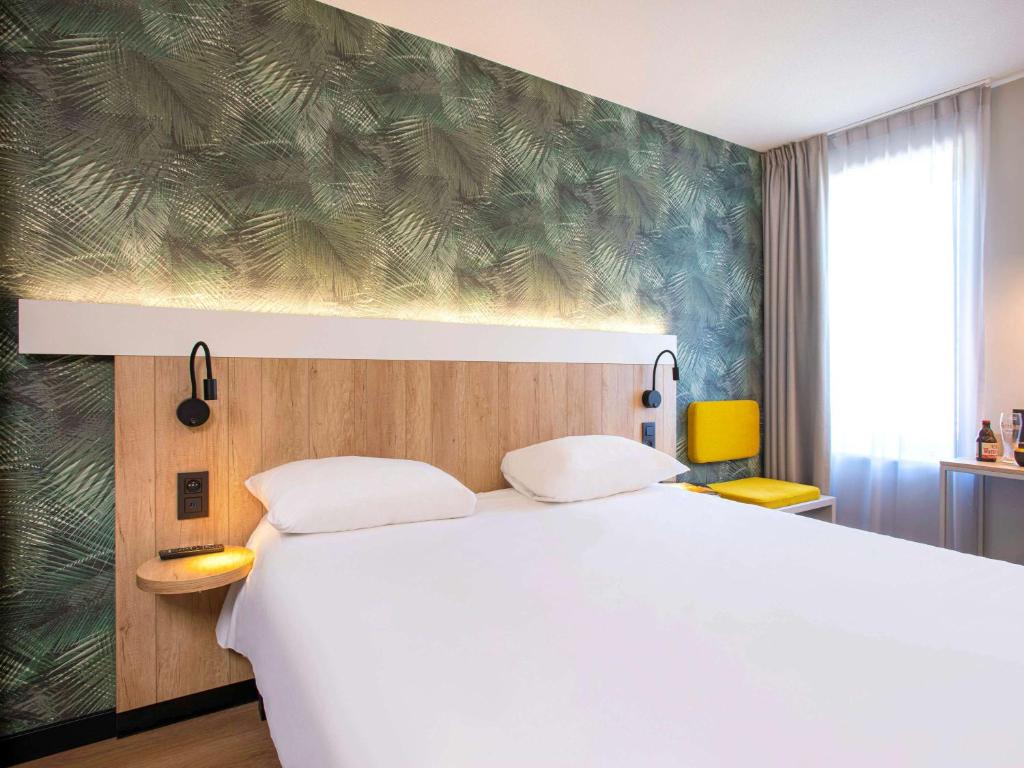滑铁卢宜必思布鲁塞尔滑铁卢酒店的卧室配有白色的床和绿色的墙壁