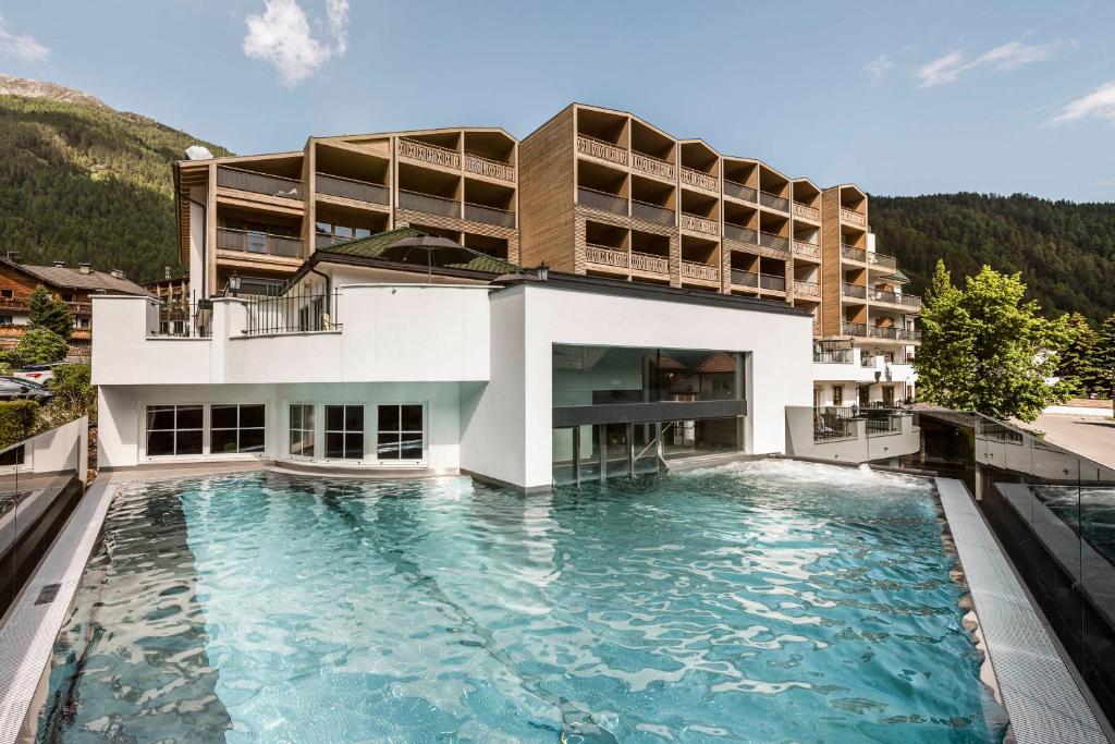 瓦勒斯法肯斯特诺温泉酒店的一座建筑前面设有游泳池