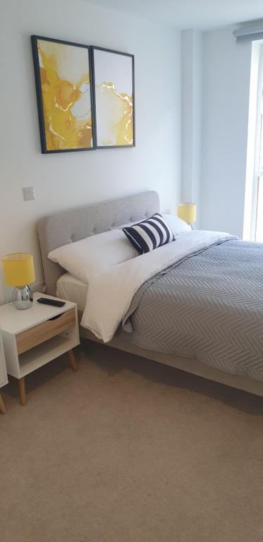曼彻斯特Quay Apartments Exchange Quay的一间卧室配有一张床和一张带台灯的桌子