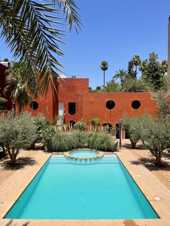 马拉喀什MORO Marrakech Boutique Hôtel的砖楼前的游泳池