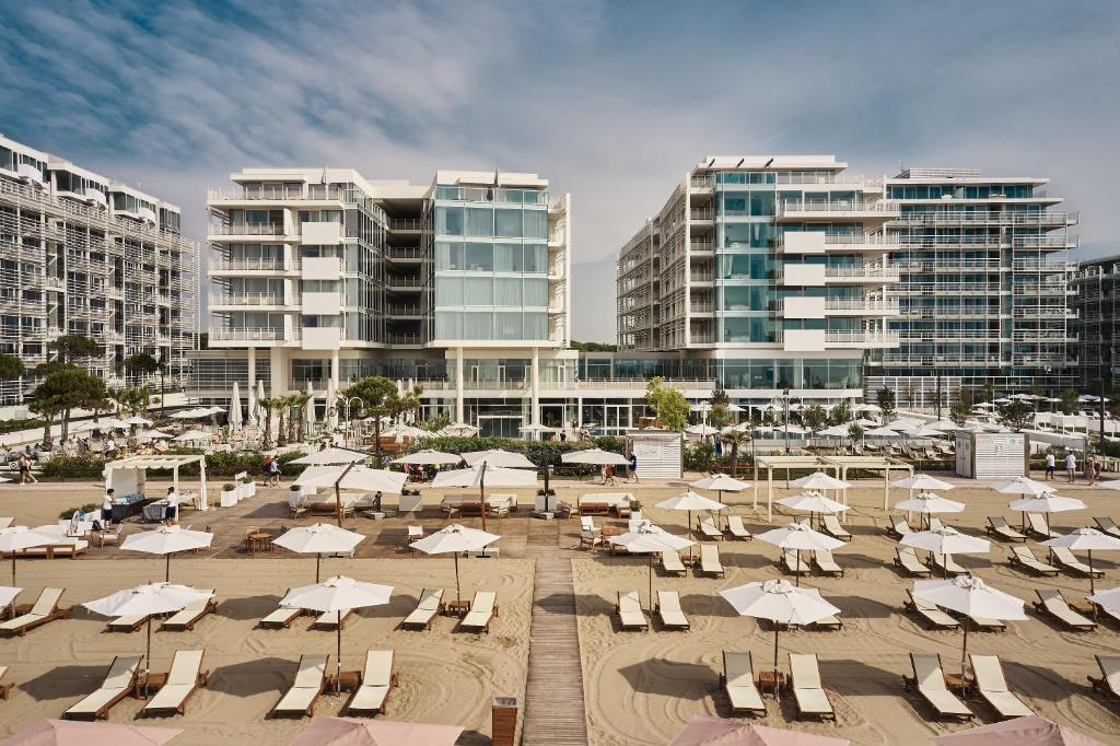 利多迪耶索罗福克斯坦恩耶索洛酒店&Spa的建筑前的海滩,配有椅子和遮阳伞