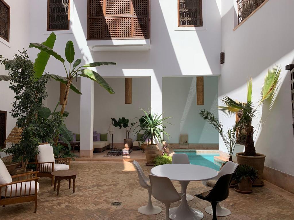 马拉喀什里亚德亚普住宿加早餐旅馆的大堂设有桌椅和游泳池
