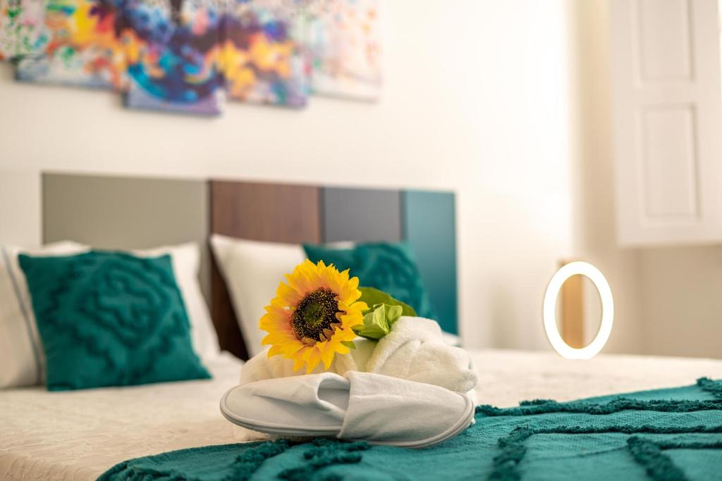 吉马良斯FERREIRA'S HOUSE Guimarães的床上的毛巾,带向日葵和镜子