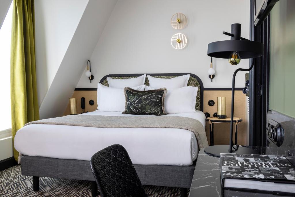 巴黎Grand Hotel Chicago的一间卧室配有一张特大号床和一张书桌