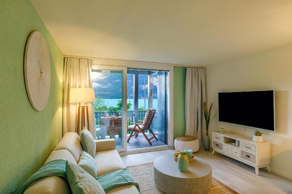 DärligenStrandhüsli directly on lake Thun的带沙发和平面电视的客厅