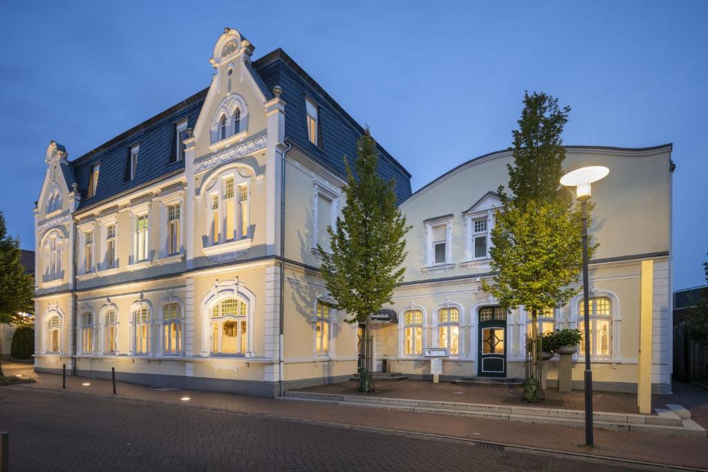 维斯贝克Visbek Hotel Stüve的前面有树木的白色大建筑