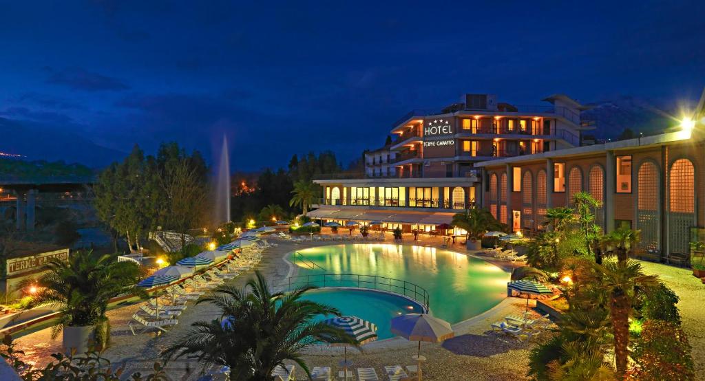 孔图尔西泰尔门卡帕索酒店的一座游泳池,在晚上在建筑物前