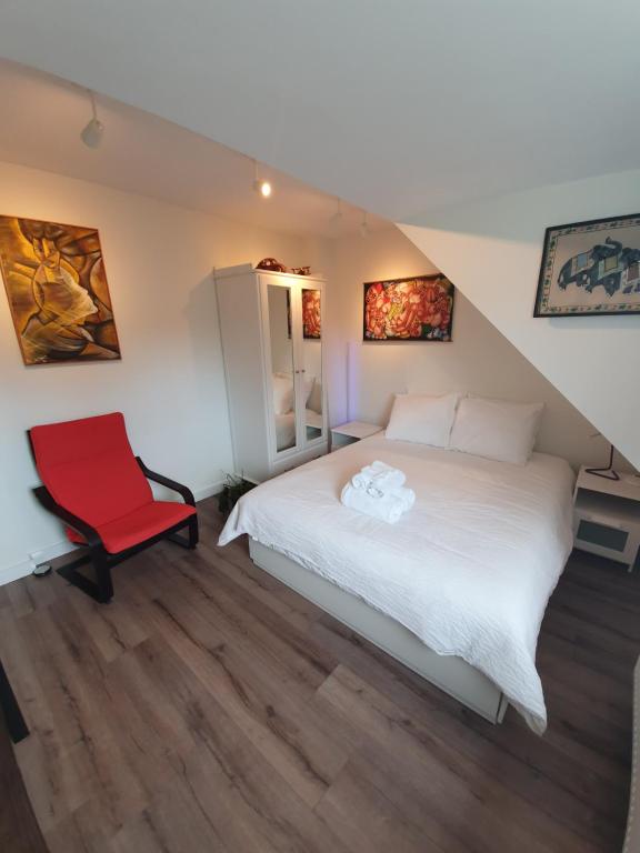 海牙Scheveningen Sea Side的一间卧室配有一张床和一张红色椅子