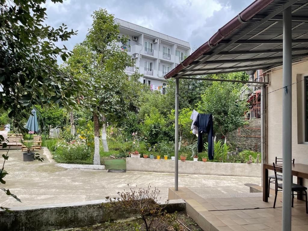 巴统Batumi Summer Hotel的花园,花园内有黑色衬衫挂在柱子上