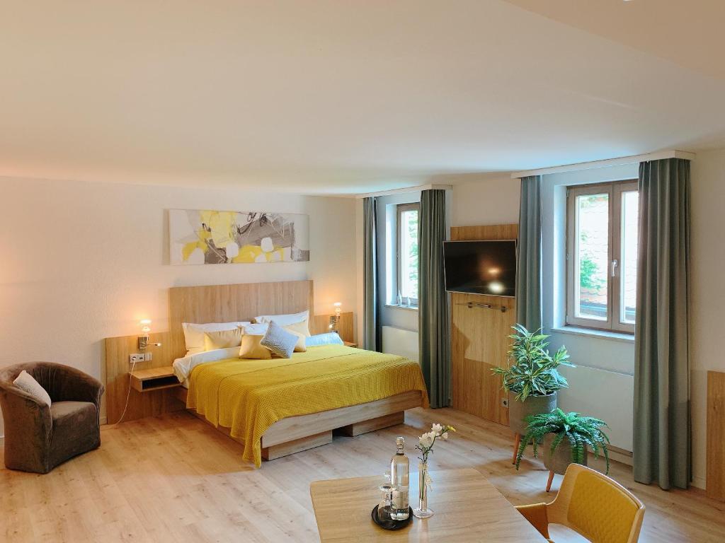 贡岑豪森鲍尔沃尔夫酒店的一间卧室配有一张黄色的床和一张桌子
