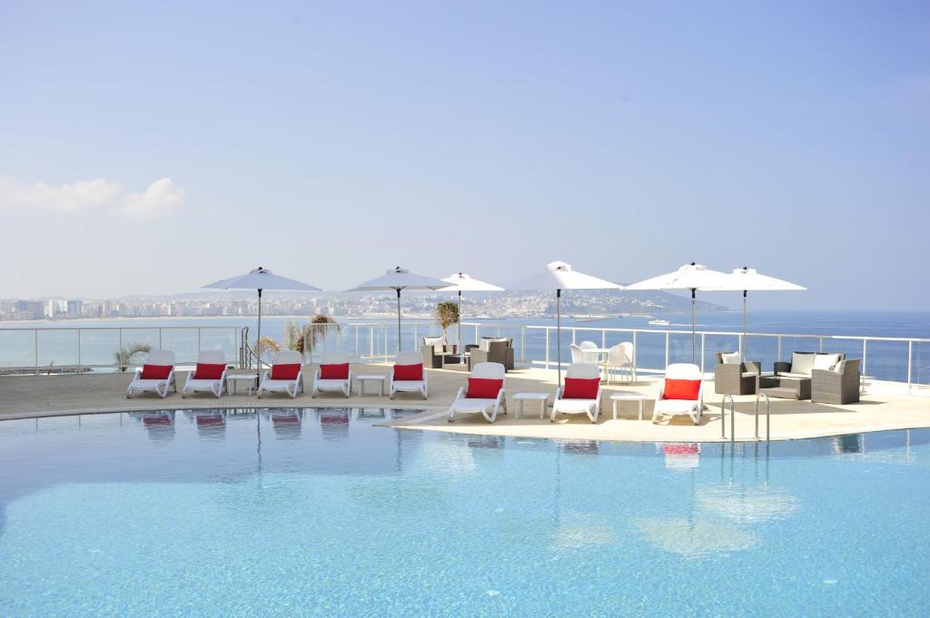 丹吉尔法拉丹吉尔酒店的一个带桌椅的游泳池以及大海