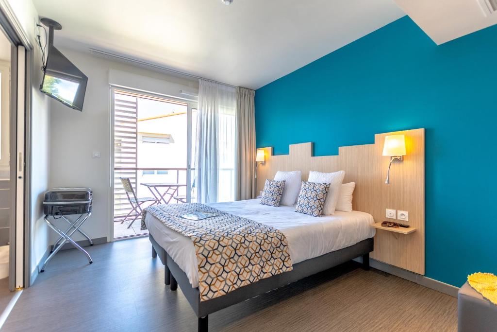 圣拉斐尔风车酒店的一间卧室设有一张蓝色墙壁的大床
