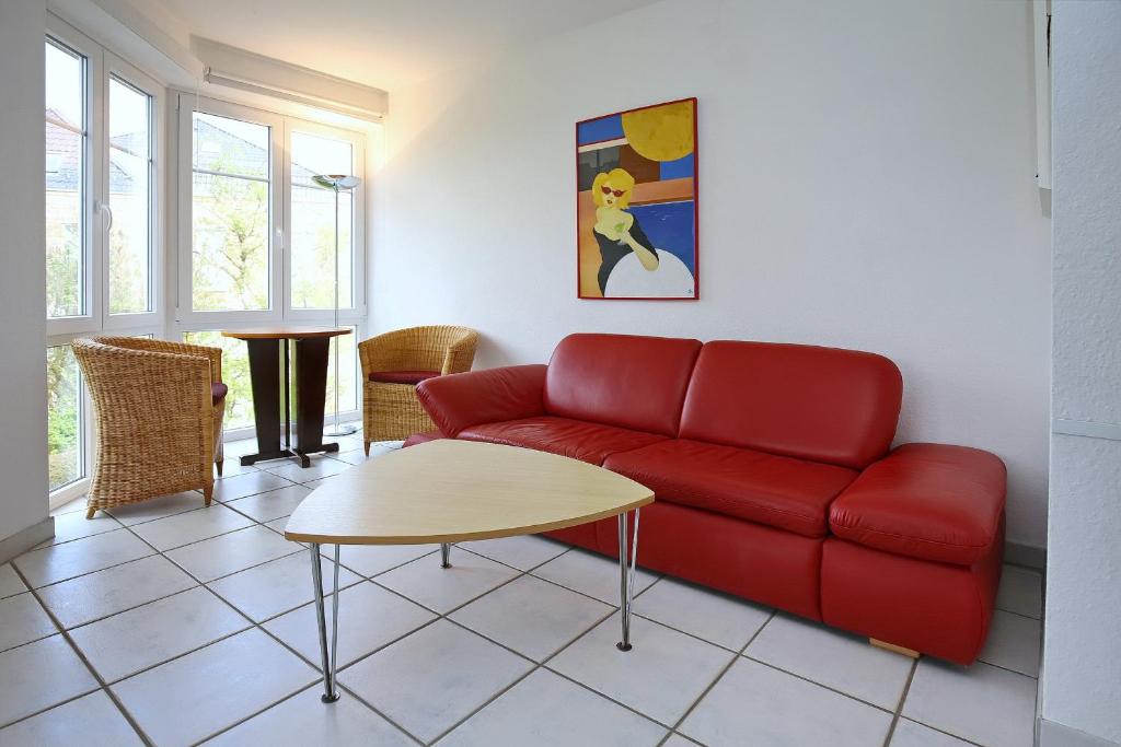博尔滕哈根Dünenblick Wohnung 44的客厅配有红色的沙发和桌子