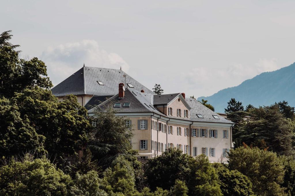 埃姆布能Hotel la Robeyere; BW Signature Collection的一座树荫小山顶上的大型房屋