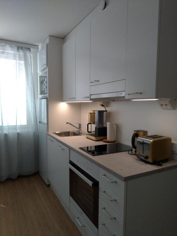 于韦斯屈莱Apartments Käyräkatu的厨房配有白色橱柜和台面