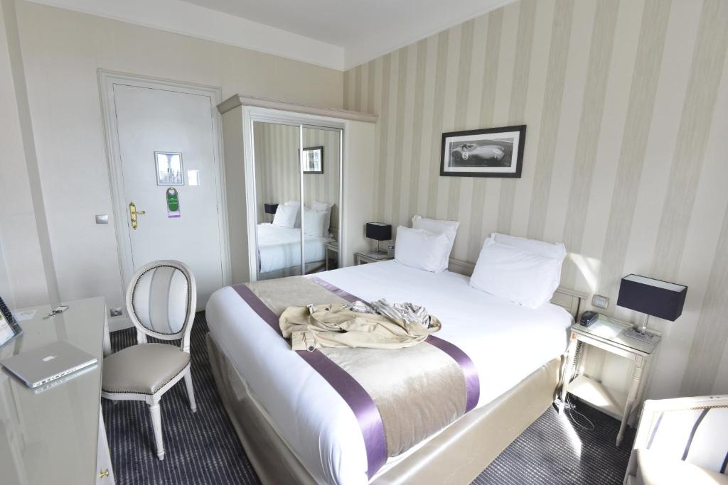 勒芒勒芒中心火车站康克迪亚酒店的配有一张床和一把椅子的酒店客房