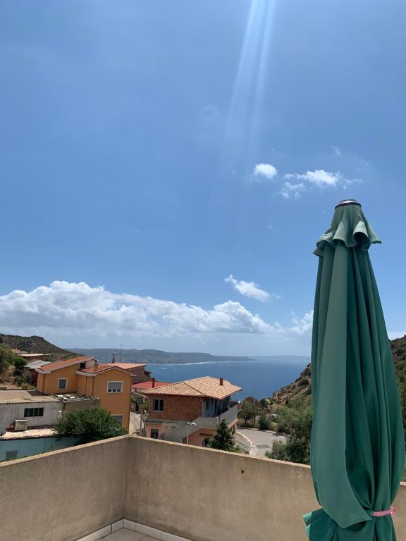 内比达Casa vacanze Nebida的阳台顶部的绿色遮阳伞