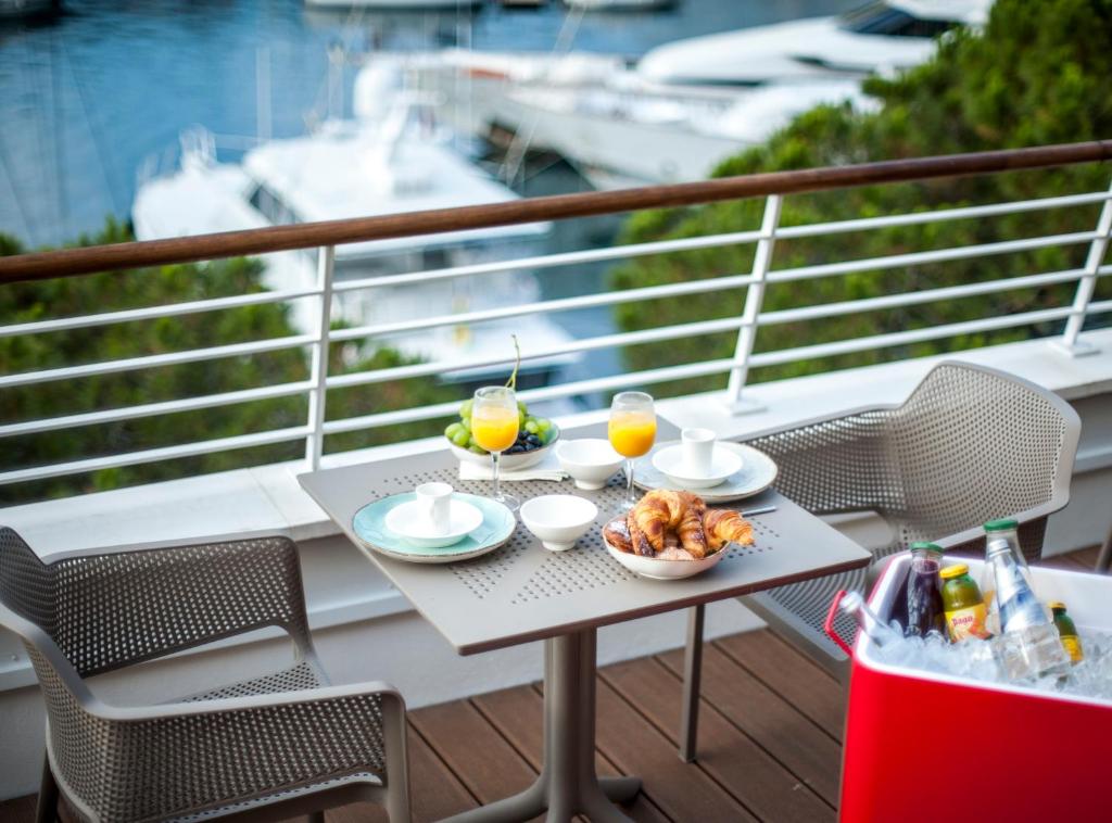 蒙特卡罗Boutique Hotel Miramar的阳台上的桌子上摆放着食物和饮料