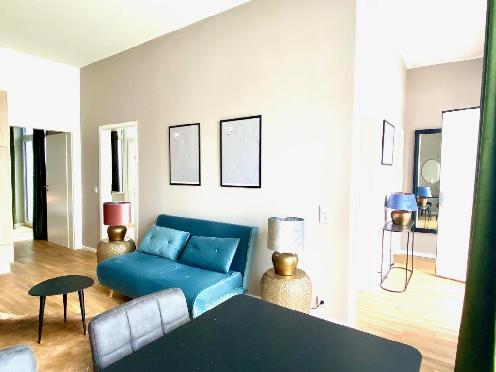 莱比锡LIVING Apartments Leipzig的客厅配有蓝色的沙发和桌子