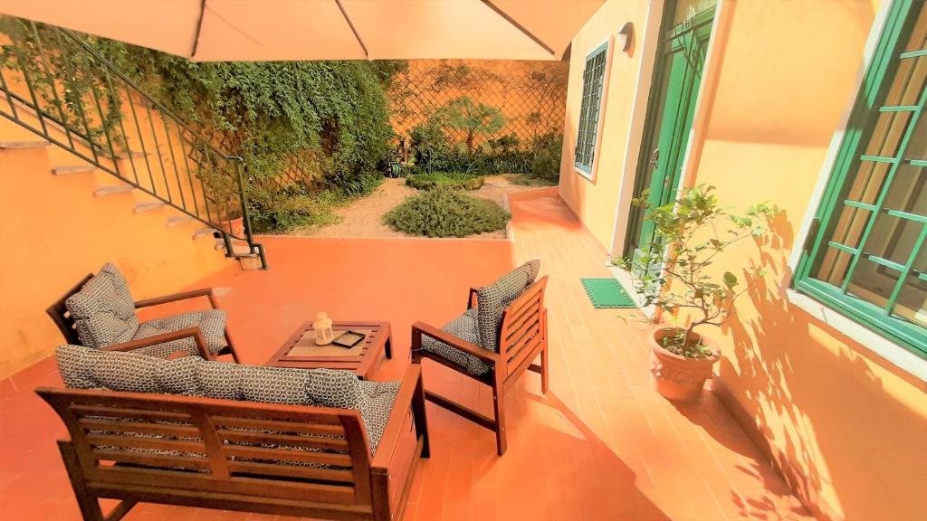 罗马第五住宿加早餐酒店的阳台配有两把椅子、一张桌子和一把伞