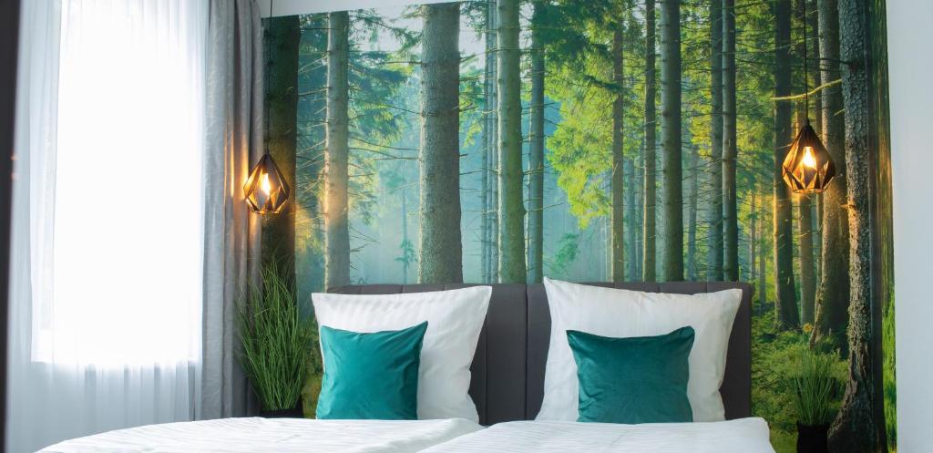萨尔堡Gästehaus&Pension Pinske的一间卧室,配有一张森林背景的床
