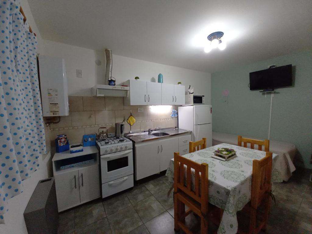 乌斯怀亚Departamentos Buen Pasar的小厨房配有桌子、炉灶和桌椅