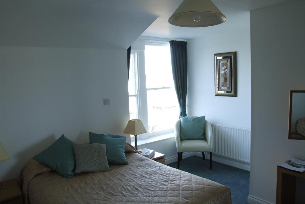 罗撒西维多利亚酒店的一间卧室设有一张床、一个窗口和一把椅子