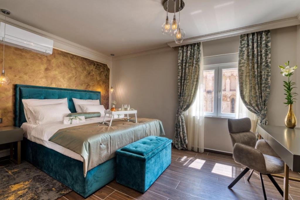 扎达尔Luxury Rooms VINDEMIÆ的一间卧室配有蓝色的床和蓝色椅子