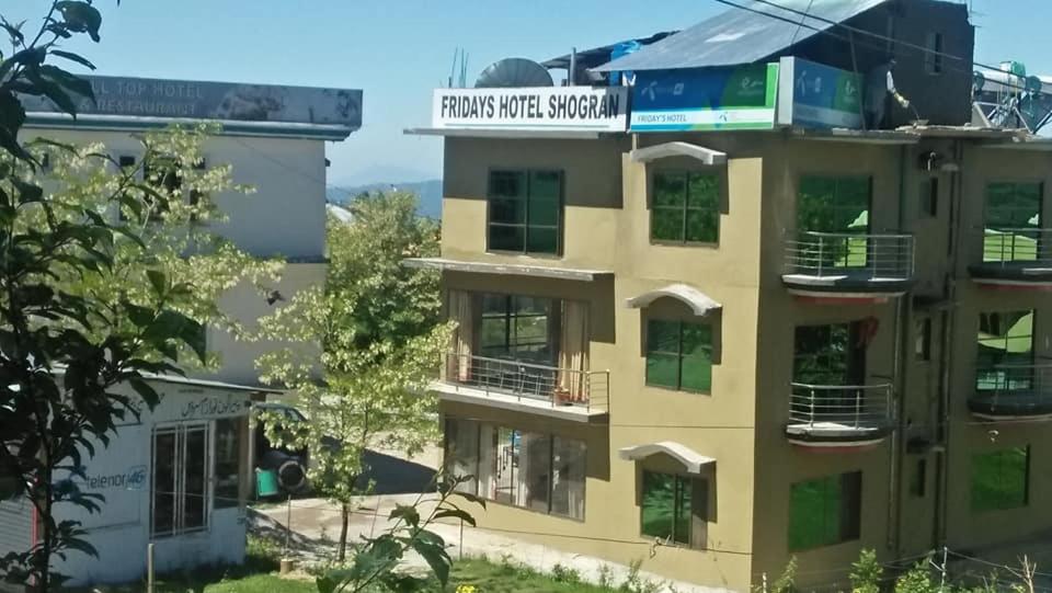 ShongranFridays Hotel的上面有标志的建筑