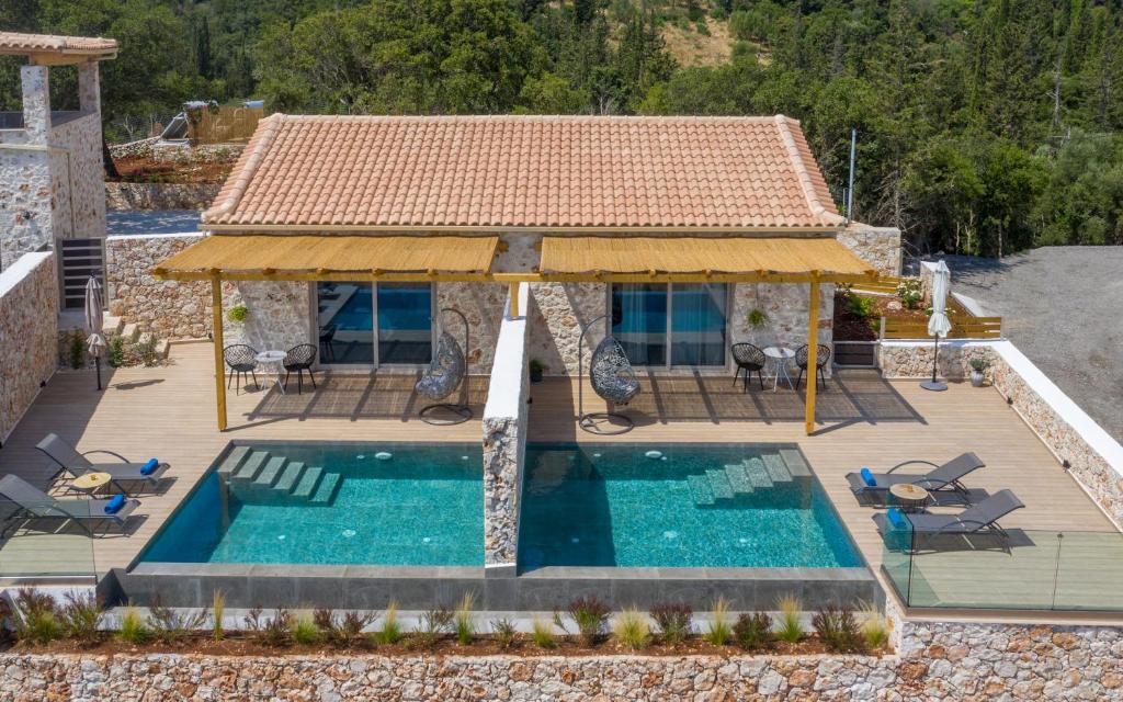 SkináriaSpartia Suites - Brand New Seaview Suites!!的游泳池与房屋的形象