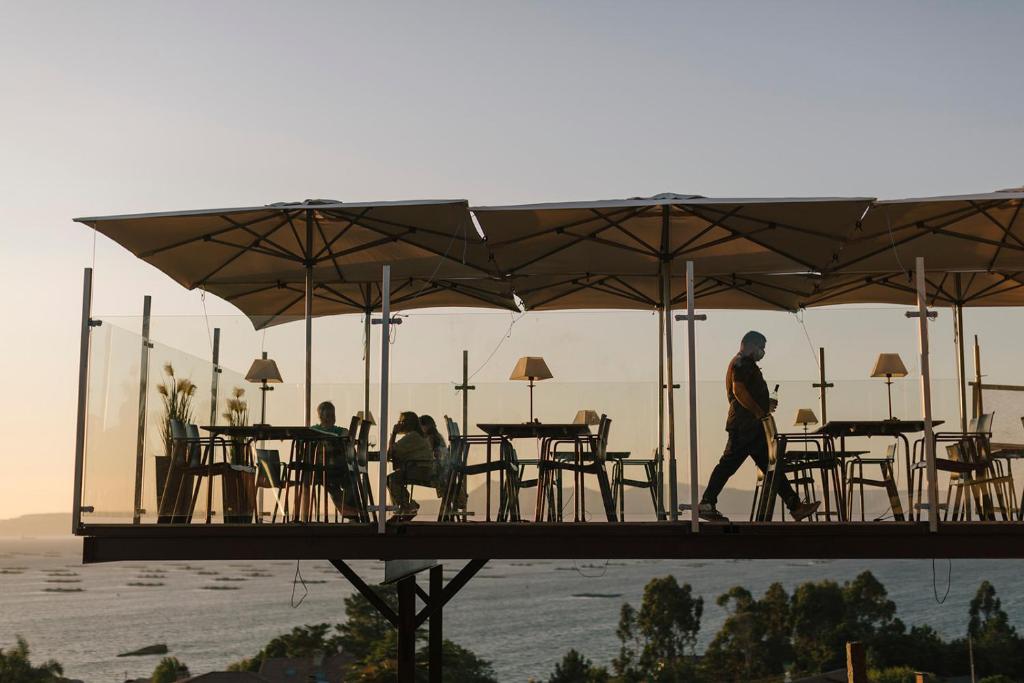 里博雷多奥卡斯特罗酒店的一位在桥上用桌子和遮阳伞行走的人