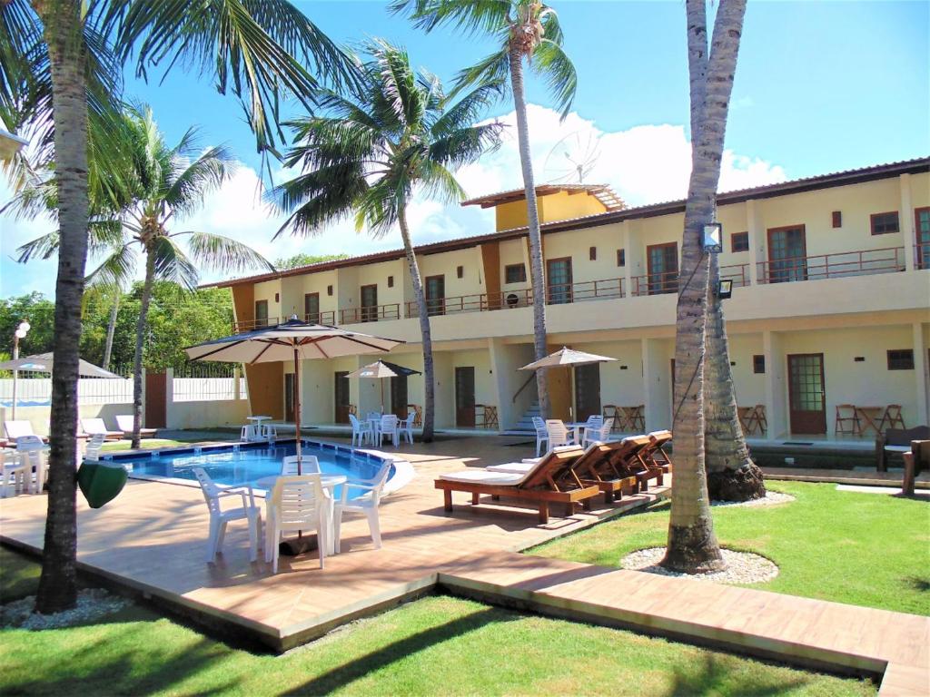 拉巴拉德纳圣安东尼奥Pousada Paraiso da Barra的一个带游泳池、椅子和棕榈树的度假村