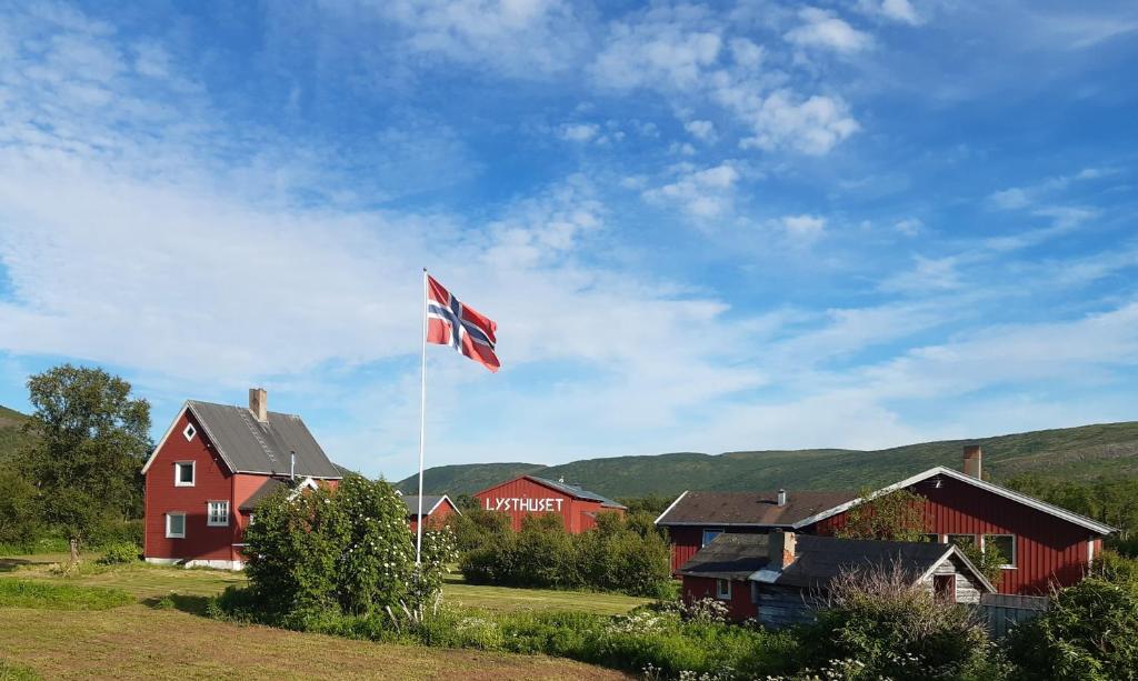 AustertanaVARANGER KITE CAMP的红房子前面悬挂的英国国旗