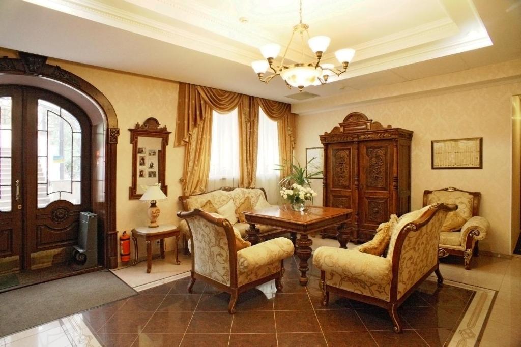 基辅银魂画廊酒店的客厅配有桌椅