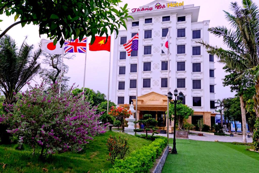 荣市Thông Đỏ Hotel的大楼前有旗帜的酒店