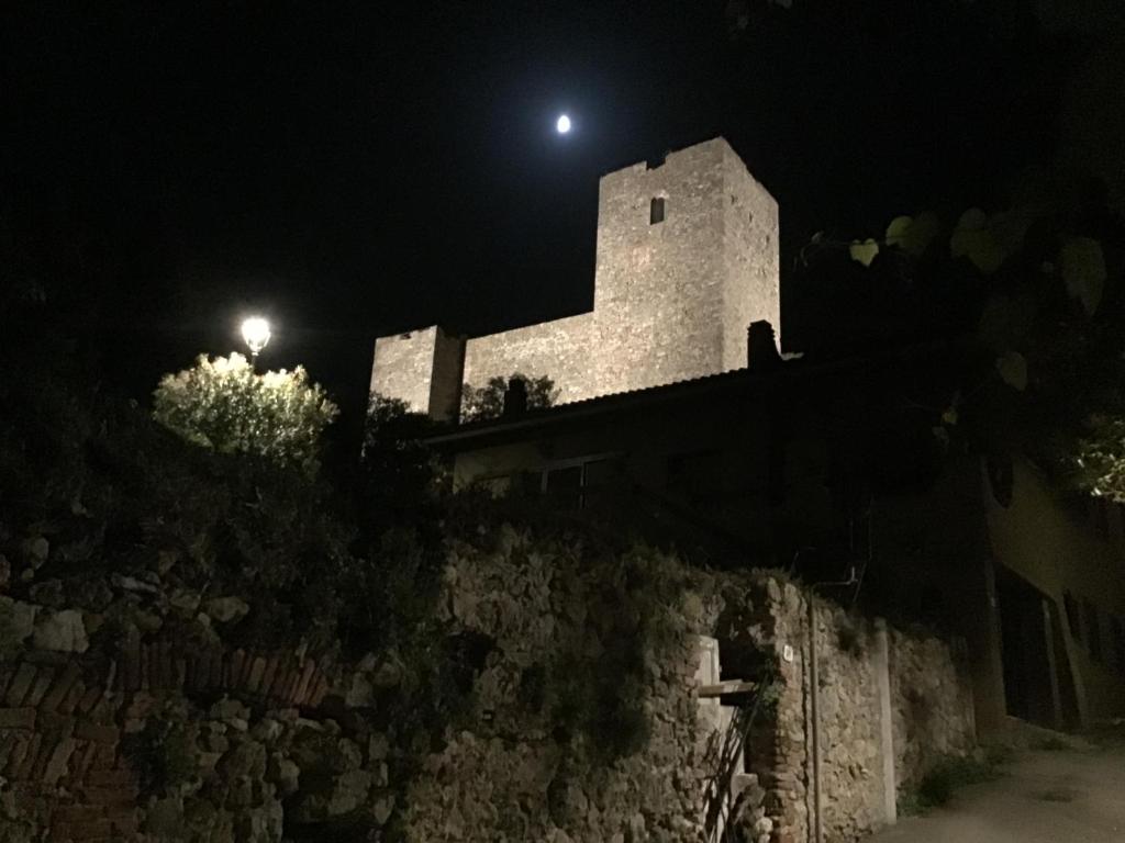塔拉莫内Casetta Terrosi的夜间墙上有灯的建筑物