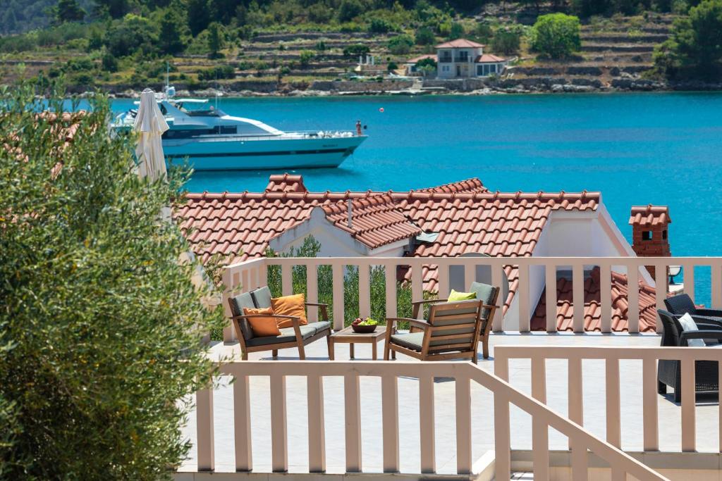 尼亚卢卡kuća za odmor Tino的阳台配有椅子和水中的船只